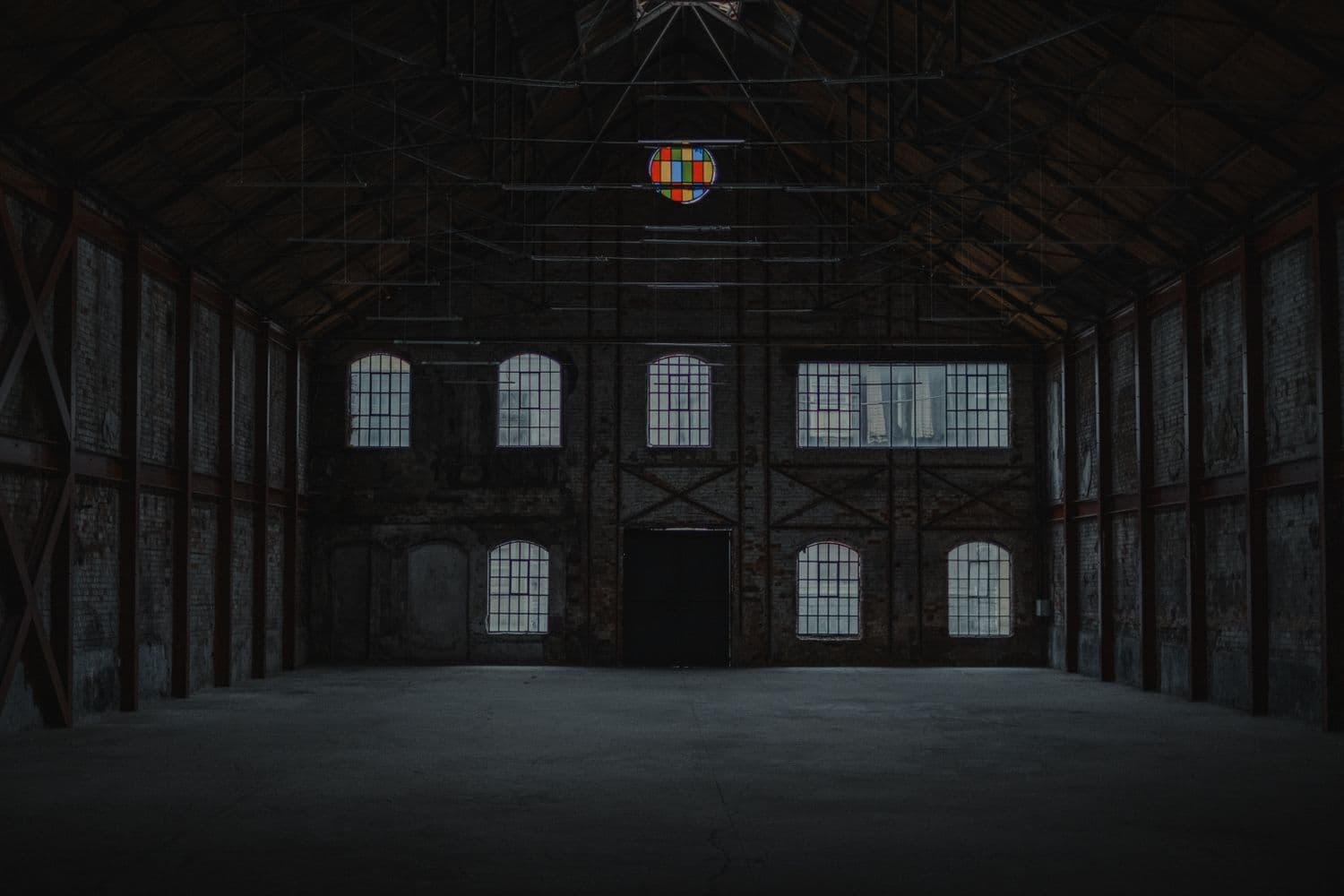 A large open agricultural building interior with a poured concrete floor.
