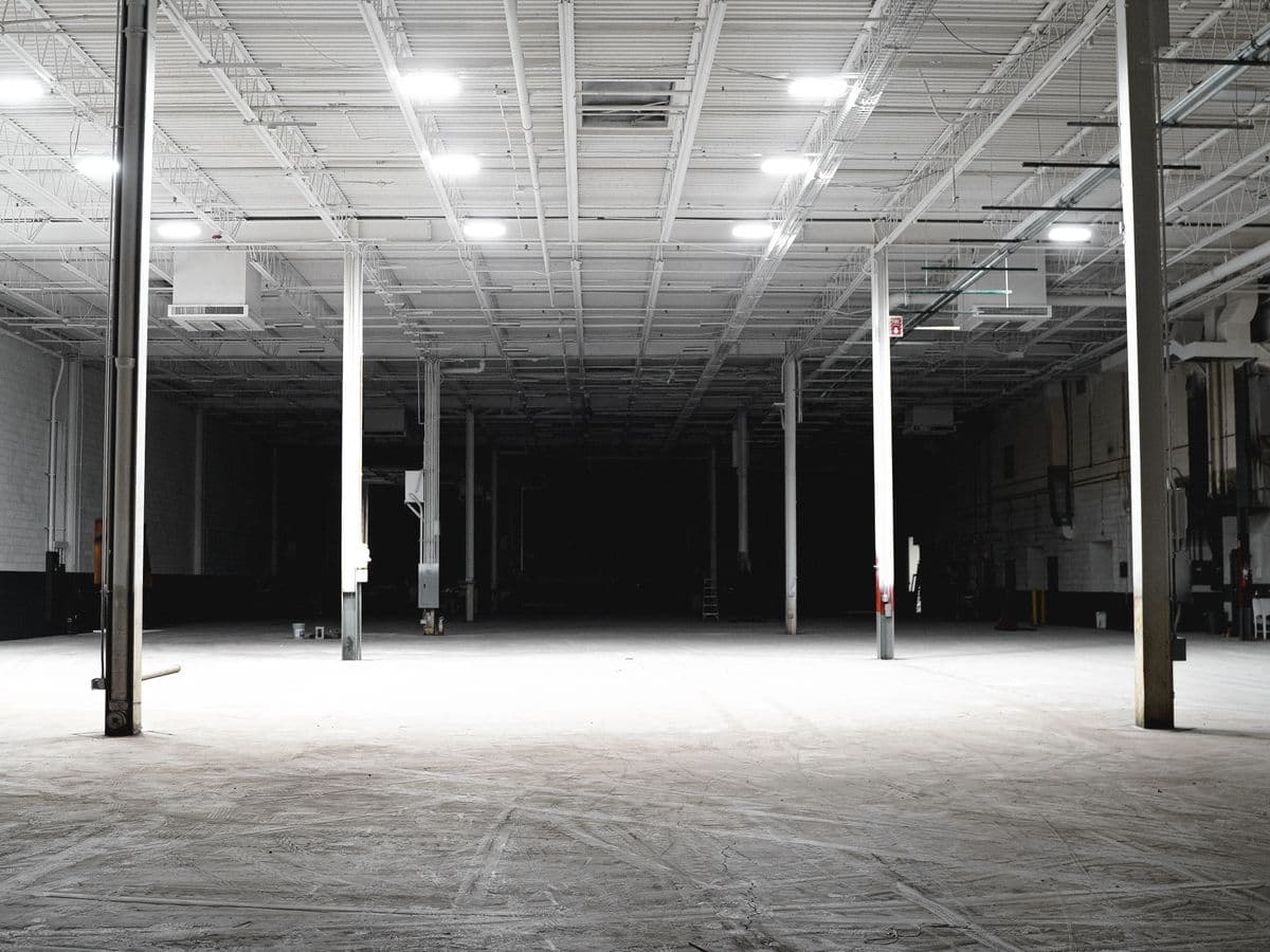 A level, finished industrial concrete floor running the length of a warehouse.